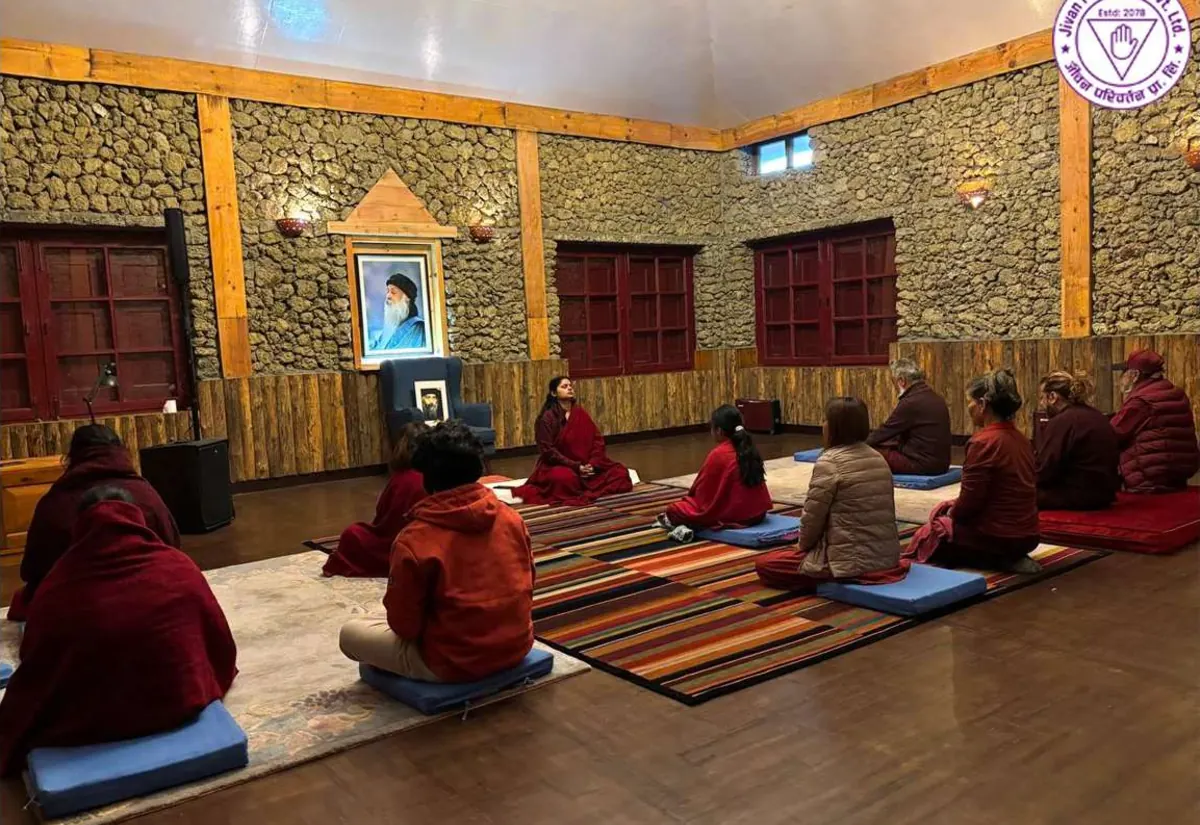 Guests sitting in silent meditation with the teacher in the stone retreat hall at Jivan Parivartan